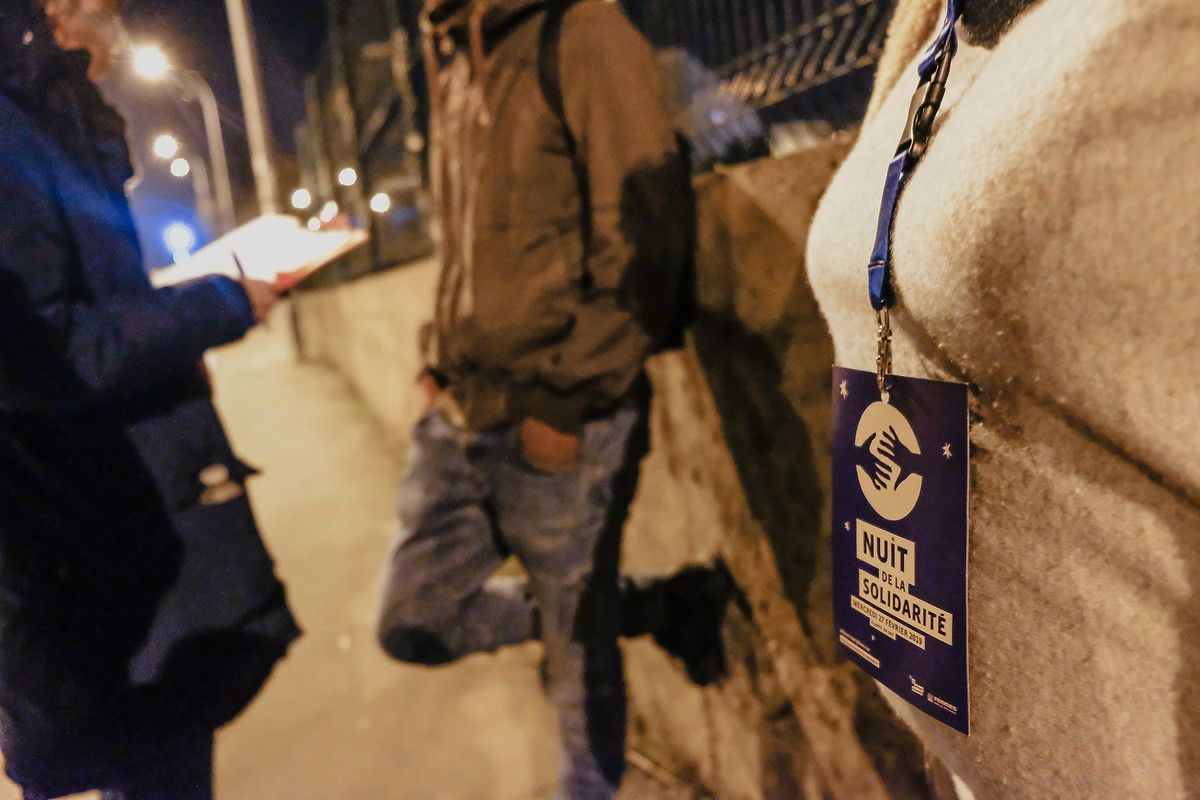 Personnes debout dans la nuit avec badge NDLS